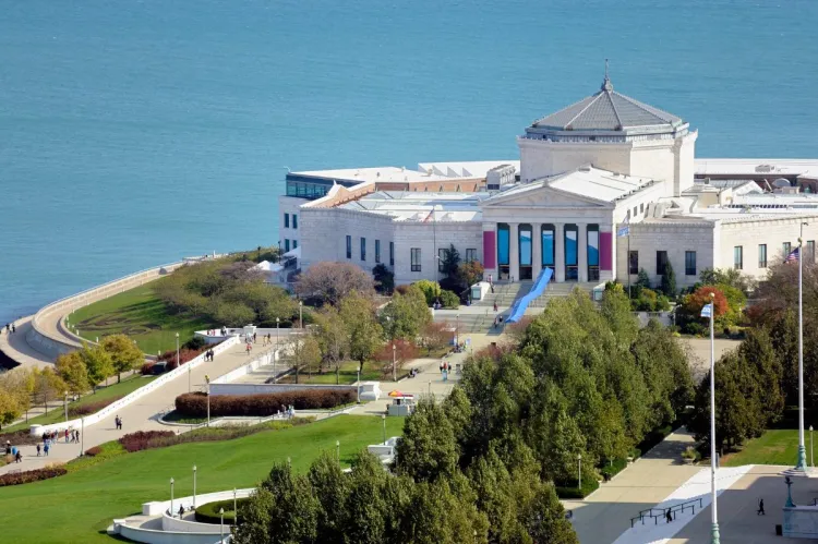Aerial view of Shedd Aquarium by Lake Michigan with classical architecture and surrounding green spaces.