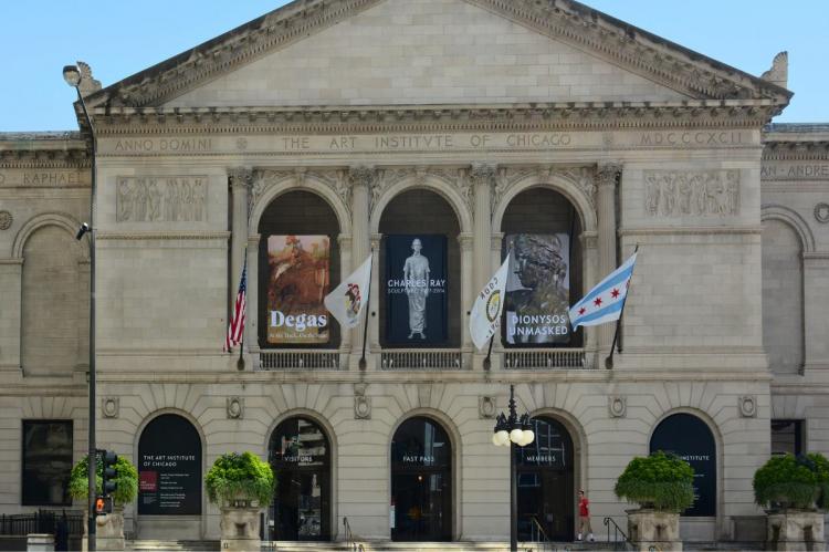 Front facade of The Art Institute of Chicago with exhibition banners and flags.