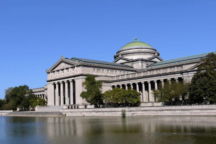 Museum of Science and Industry in Chicago with neoclassical architecture, green dome, and reflecting pond.