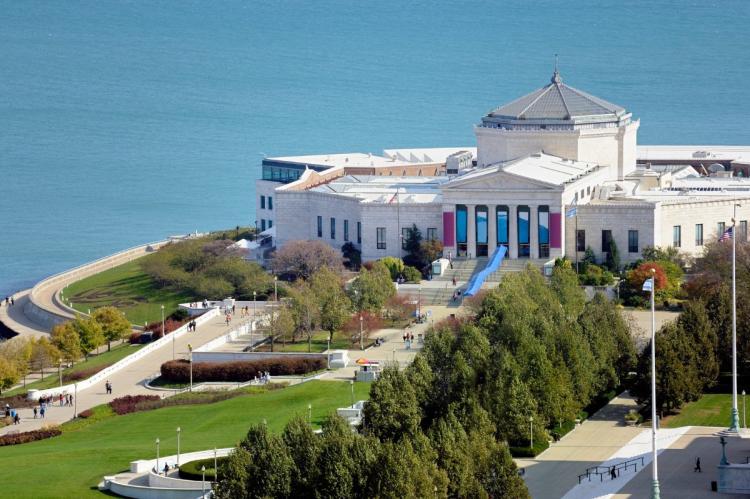 Aerial view of Shedd Aquarium by Lake Michigan with classical architecture and surrounding green spaces.
