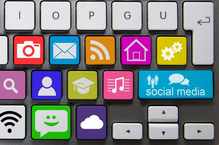 Colorful keyboard with keys replaced by icons representing photos, email, RSS feed, home, settings, social media, search, user profile, education, music, messaging, Wi-Fi, and cloud services.