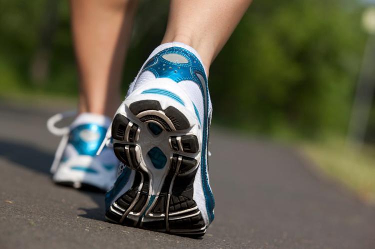 Two feet walking in trainers.
