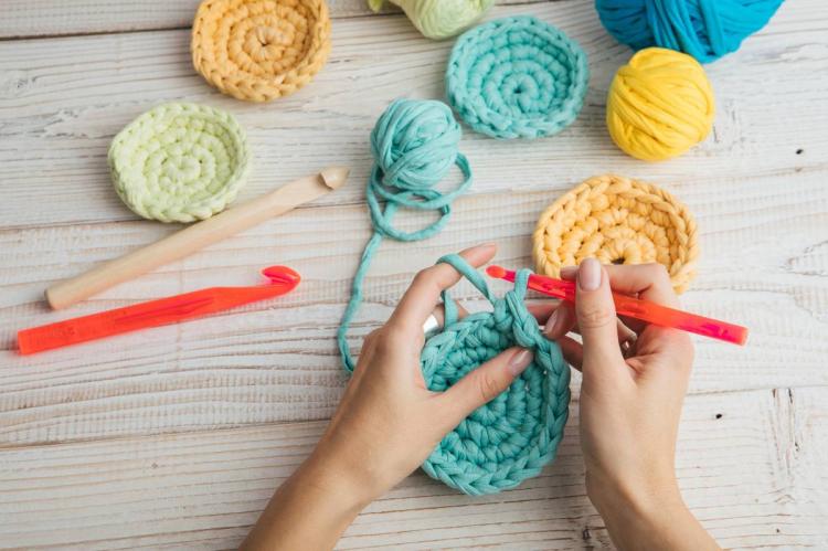 Hands knitting crochet circles.