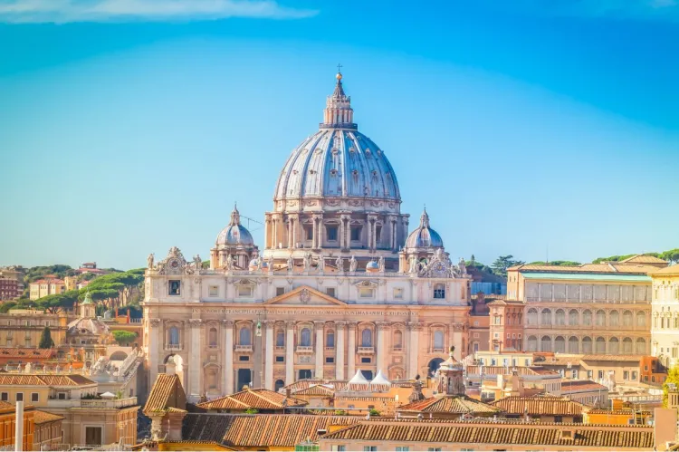 Dome and façade of St Peter's Basilica rising above the buildings of Vatican City.