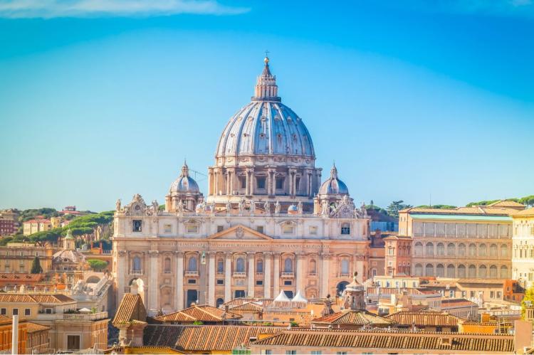 Dome and façade of St Peter's Basilica rising above the buildings of Vatican City.