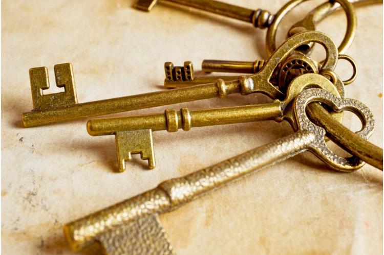 Close-up of antique brass keys arranged on a light-colored surface.