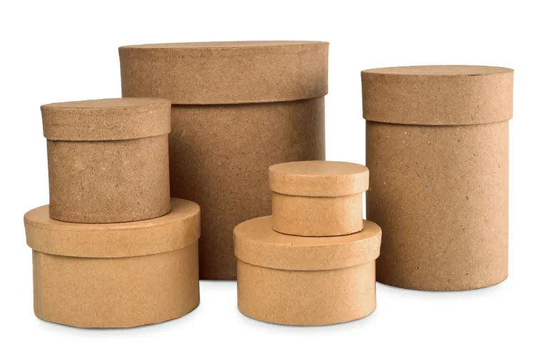 A set of plain kraft-brown papier-mâché boxes with lids in assorted round and oval shapes and sizes, on a white background.