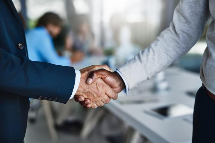 Shaking hands once in agreement.