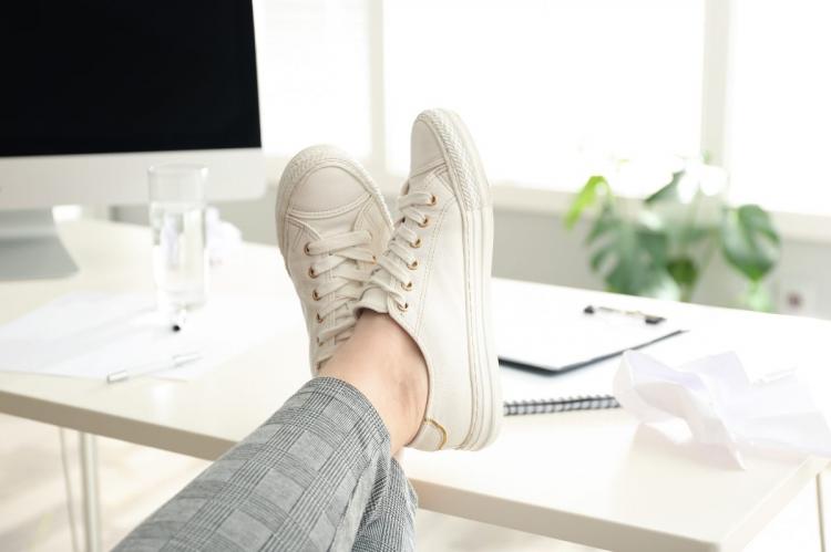 A lazy office worker with feet on the desk.